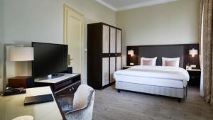 Habitación de hotel con cama grande y escritorio. en Aria Hotel Prague, en Praga