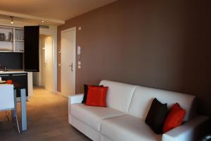 una sala de estar con un sofá blanco con almohadas rojas en Residence Ormeggio, en Grado