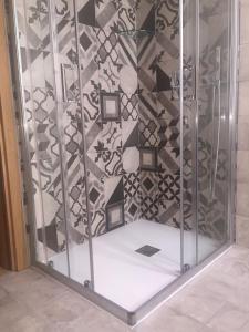 a shower with a glass door with pictures on it at Palazzo Carasi Apartments in Cremona