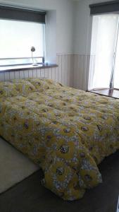 1 cama con edredón amarillo en un dormitorio en Departamento Pucon, en Pucón