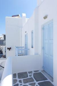 Habitación blanca con puerta y alfombra en Le Coq Apartments, en Mykonos ciudad