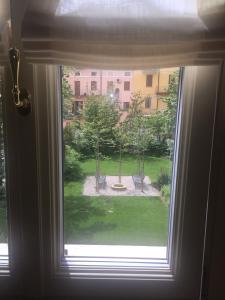 克雷莫納的住宿－Palazzo Carasi Apartments，享有庭院景致的开放式窗户