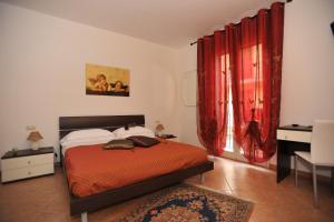 a bedroom with a bed and a red curtain at Da Paolina in Pozzallo