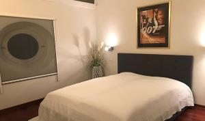 Un dormitorio con una cama blanca y una foto en la pared en Regina Elena en Calambrone