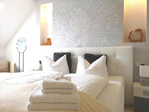 ein Schlafzimmer mit einem weißen Bett und Handtüchern darauf in der Unterkunft Kunst Pension Frahm in Basthorst