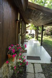 - une terrasse couverte avec des fleurs roses sur le côté de la maison dans l'établissement beit nofesh waiss, à Bet Hillel