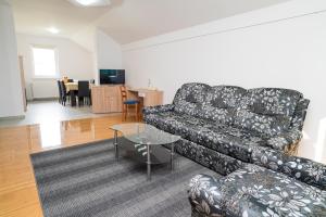uma sala de estar com um sofá e uma mesa em Tina Rooms em Velika Gorica
