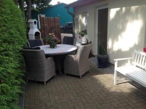 a patio with a table and chairs and a white bench at Ferienhaeuser-Am-Eichenberg-Haus-2 in Blankenburg