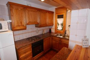 a kitchen with wooden cabinets and a stove top oven at Cozy Apartment in Alp in Alp