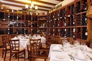 a restaurant with white tables and bottles of wine at Finca Eslava in Antequera