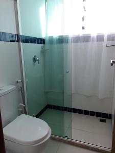 a bathroom with a toilet and a glass shower at Pousada Bahia Inn in Morro de São Paulo