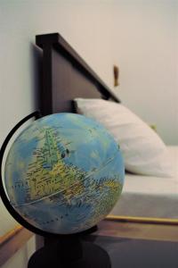 een bol op een tafel naast een bed bij Asia's place in Kavala