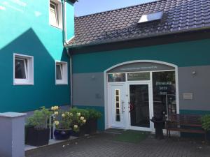 een blauw gebouw met een deur en een bank buiten bij Ferienwohnung Westerburg in Westerburg
