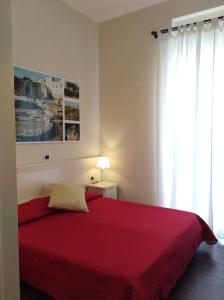 1 dormitorio con cama roja y ventana en DomuS al Corso con servizio B&B, en Canosa di Puglia