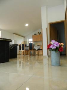 un soggiorno con tavolo, sedie e vaso di fiori di Apartment Gordana a Pola (Pula)