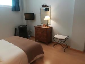 バハマルにあるBajamarのベッドルーム(ベッド1台、ランプ、椅子付)