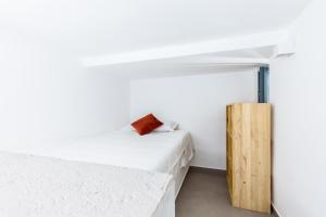 パレルモにあるLoft Piazza Marina by DomuSicilyの白いベッドと木製キャビネット付きのベッドルーム1室が備わります。