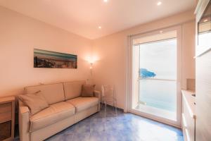 un soggiorno con un divano e una grande finestra di Le Esperidi a Ravello