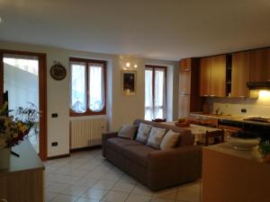 een woonkamer met een bank en een keuken bij Appartamento Borgo Antico in Oliveto Lario