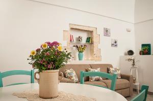 a room with a table with a vase of flowers on it at Iannet & Co. in Locorotondo +24 photos