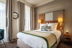 a hotel room with a large bed and a large window at Le Tourville Eiffel in Paris