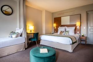 Llit o llits en una habitació de Hôtel Le Tourville by Inwood Hotels