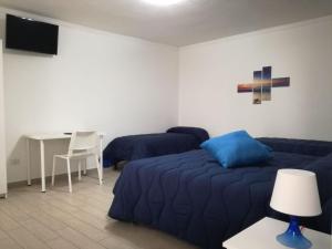 a bedroom with two beds and a table and a desk at B&B dal Gallo in Battipaglia