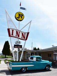 un vecchio camion blu parcheggiato di fronte a un motel di JR Inn a Soda Springs