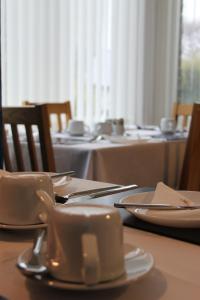 a table with plates and utensils on top at The St. Leonards Guest House in Shanklin