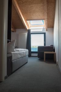 ein Schlafzimmer mit einem Bett, einem Sofa und einem Fenster in der Unterkunft Hotel Alter Hafenspeicher in Stralsund