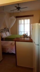 a kitchen with a refrigerator and a bedroom with a bed at Castello Bellos studios in Keri
