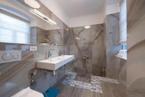 uma casa de banho com um lavatório e um chuveiro em Vista dał Mare em Split
