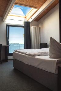 ein Schlafzimmer mit einem Bett und einem großen Fenster in der Unterkunft Hotel Alter Hafenspeicher in Stralsund