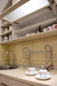 a kitchen counter with two cups and a sink at Zafir 1 in Vrnjačka Banja +6 photos