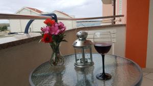 szklany stół z wazonem kwiatów i kieliszkiem wina w obiekcie Roky w mieście Povljana