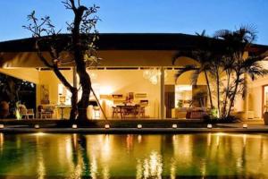 a house with a swimming pool at night at Villa Anema Umalas in Seminyak