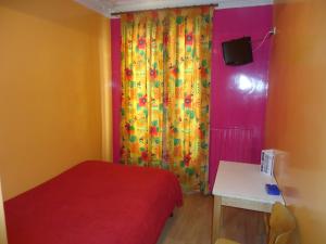 a room with a bed and a curtain and a table at Hotel des Belges in Paris