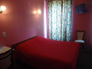 a red bedroom with a red bed and a window at Hotel des Belges in Paris