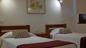 a room with two beds and a picture on the wall at Apartamentos da Balaia in Albufeira