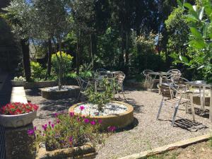 um grupo de mesas e cadeiras num jardim com flores em Alberg Solidança Hostel em Palafrugell