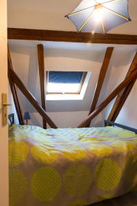 ein Schlafzimmer mit einem Bett und einem Dachfenster in der Unterkunft Gîte - Logement rénové dans ferme alsacienne in Pfettisheim