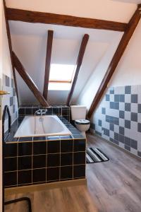 ein Bad im Dachgeschoss mit einer Badewanne und einem WC in der Unterkunft Gîte - Logement rénové dans ferme alsacienne in Pfettisheim