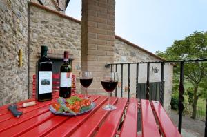un tavolo con due bicchieri di vino e un piatto di cibo di Camere Alabastro Fontesettimena a Volterra