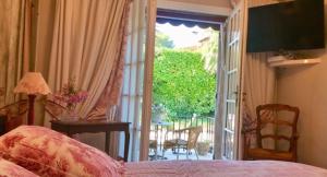 a bedroom with a bed and a door to a patio at Villa l'Air du temps in Juan-les-Pins +21 photos