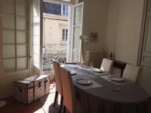 ein Esszimmer mit einem Tisch und einem großen Fenster in der Unterkunft ville Pépin in Saint-Malo