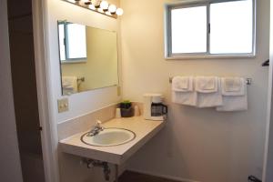 bagno con lavandino, specchio e asciugamani di JR Inn a Soda Springs