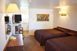 una camera d'albergo con due letti e una televisione di JR Inn a Soda Springs