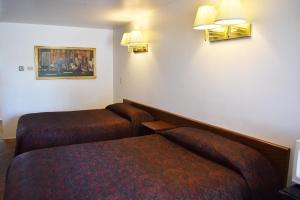 una camera d'albergo con due letti e luci sul muro di JR Inn a Soda Springs