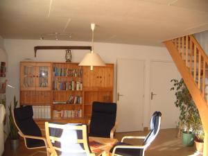 sala de estar con sillas, mesa y estante para libros en Maison Neuve Grandval, en Grandval