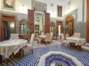 un ristorante con tavoli e sedie in una stanza di Dar Roumana a Fes